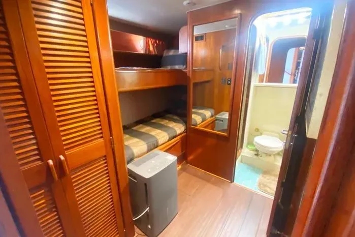 Slide: The Image of 1990 Viking Motor Yacht interior with bunk beds, wooden cabinetry, and bathroom. - 31