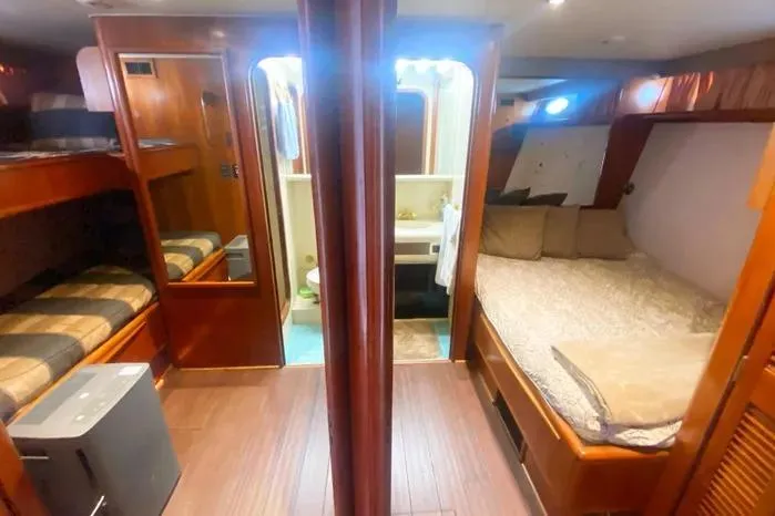 Slide: The Image of 1990 Viking Motor Yacht interior with cozy sleeping quarters and wooden finishes. - 33