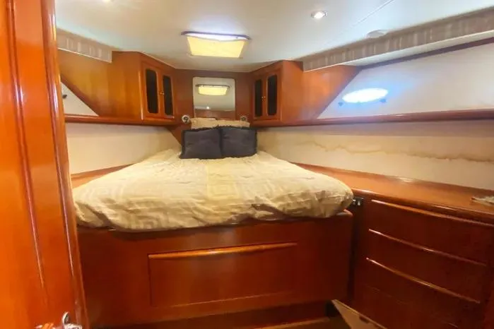 Slide: The Image of Cozy bedroom interior of 1990 Viking Motor Yacht with wooden cabinetry and soft lighting. - 36