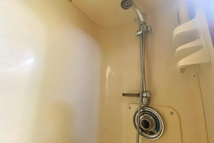 Slide: The Image of Shower area in a 1990 Viking Motor Yacht, featuring a handheld showerhead and control panel. - 38