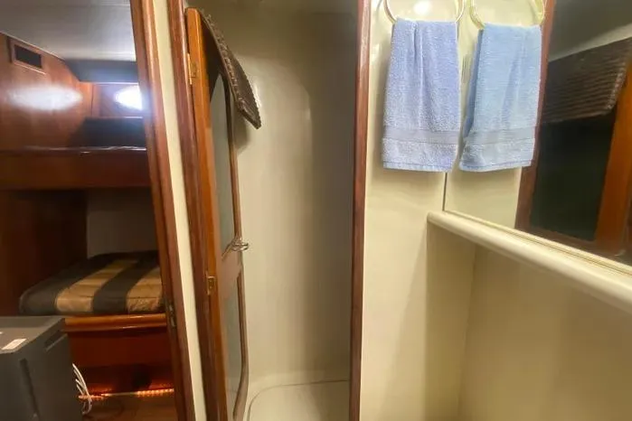 Slide: The Image of Interior of 1990 Viking Motor Yacht with shower, towels, and cozy sleeping area. - 39