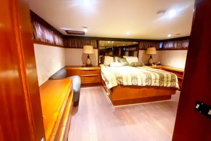 Slide: The Image of Luxurious 1990 Viking Motor Yacht bedroom with elegant wood furnishings and ambient lighting. - 46