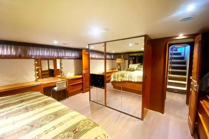 Slide: The Image of Luxurious 1990 Viking Motor Yacht bedroom with mirrored closet and elegant wood finishes. - 51