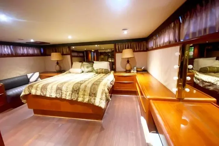 Slide: The Image of Luxurious 1990 Viking Motor Yacht bedroom with elegant wood furnishings and ambient lighting. - 52