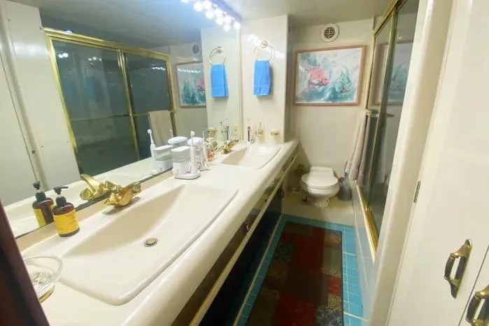 Slide: The Image of Luxurious 1990 Viking Motor Yacht bathroom with double sinks, gold fixtures, and elegant decor. - 56