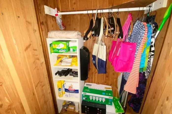 Slide: The Image of Storage closet on a 1990 Viking Motor Yacht with shelves, hangers, and cleaning supplies. - 57