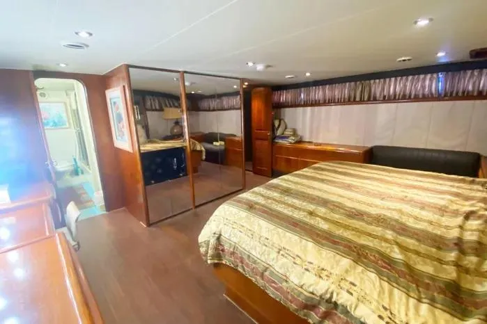 Slide: The Image of Luxurious 1990 Viking Motor Yacht bedroom with elegant wood finishes and spacious layout. - 60