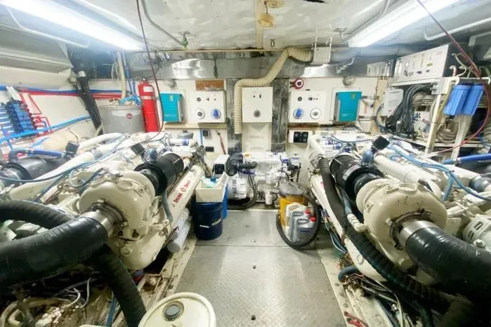 Slide: The Image of Engine room of a 1990 Viking Motor Yacht with dual engines and control panels. - 65