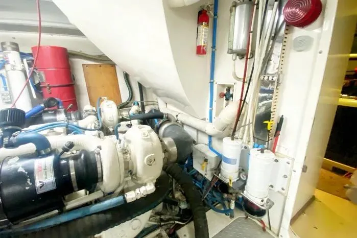 Slide: The Image of Engine room of a 1990 Viking Motor Yacht, featuring mechanical components and safety equipment. - 67