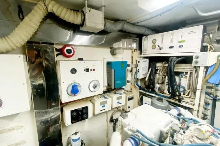 Slide: The Image of Engine room of a 1990 Viking Motor Yacht with various control panels and equipment. - 68