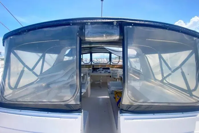 Slide: The Image of 1990 Viking Motor Yacht interior with clear canopy, showcasing helm and seating area. - 69