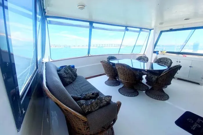Slide: The Image of Spacious interior of 1990 Viking Motor Yacht with wicker furniture and ocean view. - 7