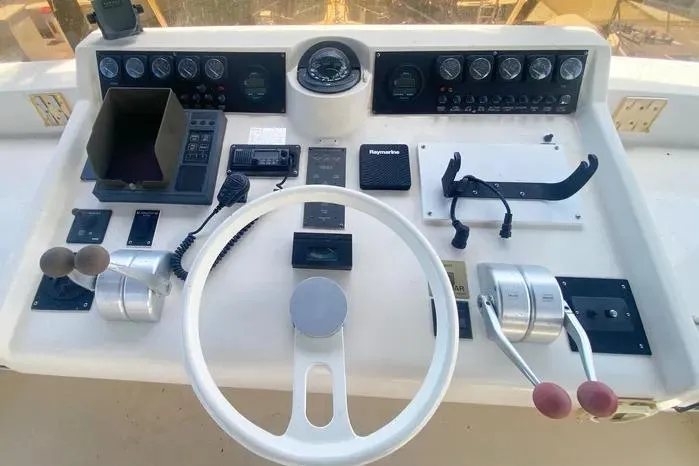 Slide: The Image of 1990 Viking Motor Yacht helm with steering wheel and control panel. - 70