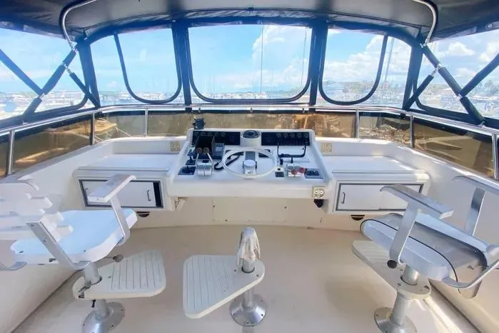 Slide: The Image of 1990 Viking Motor Yacht helm with dual captain chairs and panoramic windows. - 72