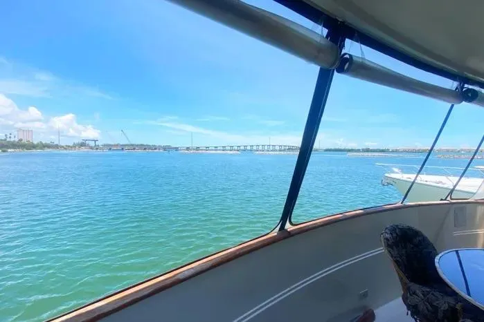 Slide: The Image of 1990 Viking Motor Yacht view of serene blue waters and distant bridge. - 9