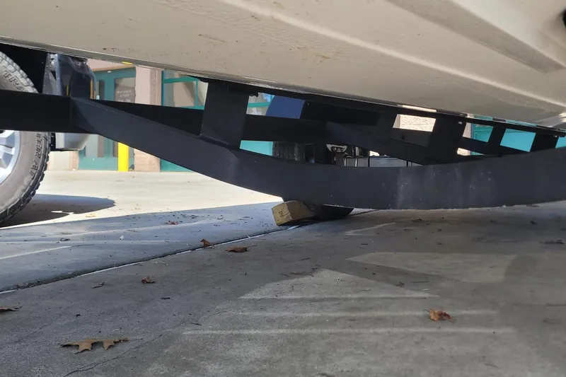 Slide: The Image of 2024 Tahoe T21 trailer with a wooden block support on concrete surface. - 15