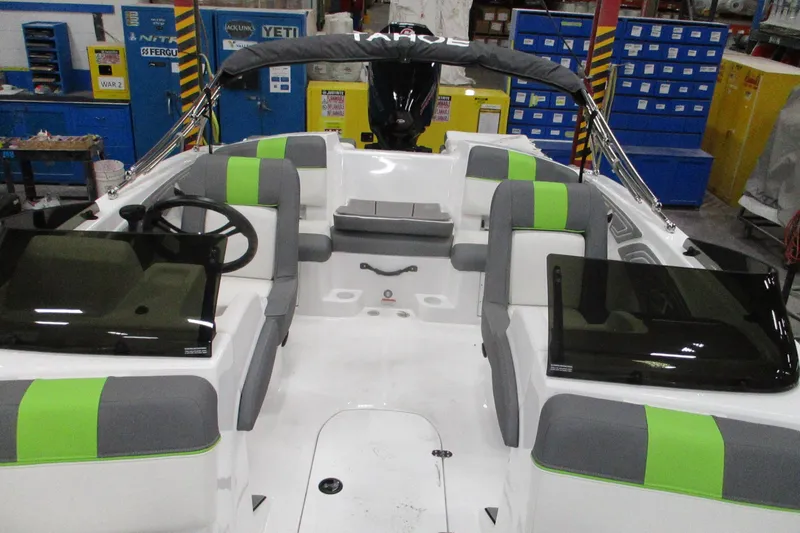 Slide: The Image of 2024 Tahoe T21 boat interior with green and gray seating, dual consoles, and steering wheel. - 19