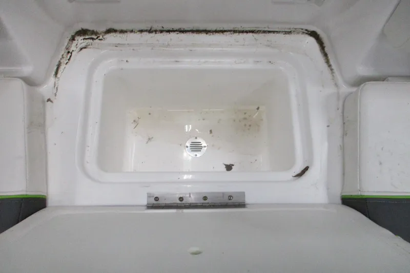 Slide: The Image of 2024 Tahoe T21 boat storage compartment with drain, showing dirt and debris. - 3