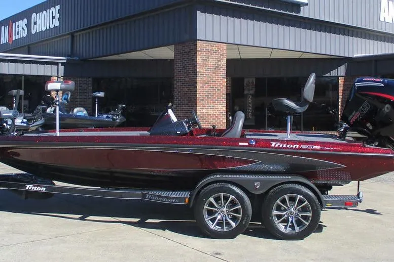 Slide: The Image of 2026 Triton 20XP Patriot boat on trailer outside dealership. - 1