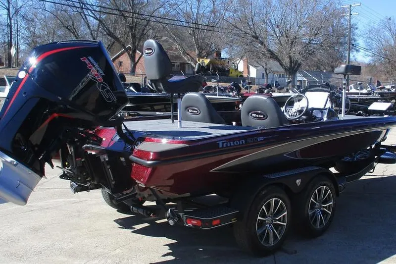 Slide: The Image of 2026 Triton 20XP Patriot boat with powerful outboard motor, parked on a trailer. - 2