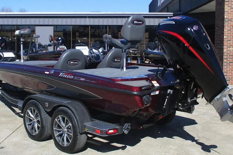 Slide: The Image of 2026 Triton 20XP Patriot boat with dual axle trailer, parked outdoors. - 3