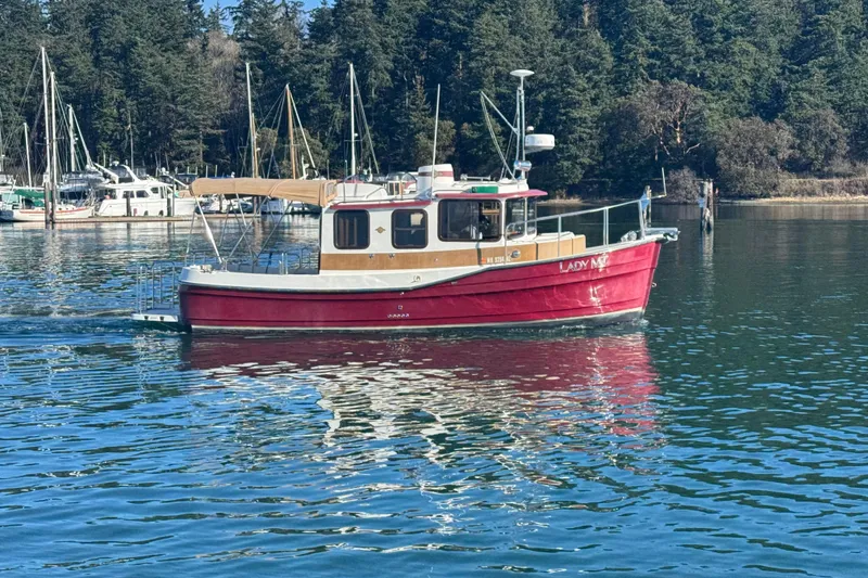 The Image of 2010 Ranger Tugs R-25 SC boat on calm water near a forested marina. - 0