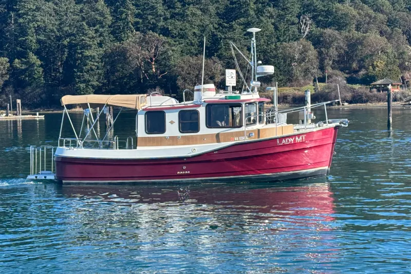 Slide: The Image of 2010 Ranger Tugs R-25 SC boat on calm water, surrounded by trees. - 3