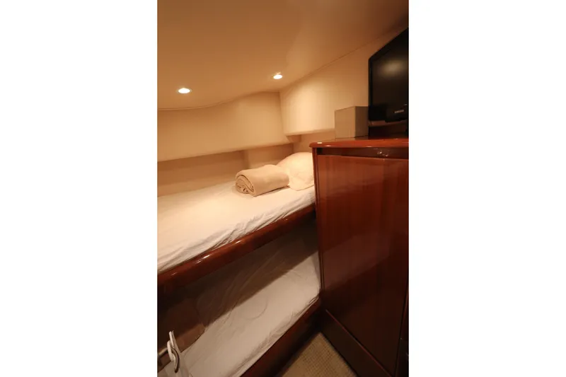Slide: The Image of Cozy cabin interior of 2011 Viking 46 Convertible yacht with bunk beds and wooden cabinetry. - 11