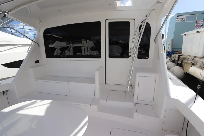 Slide: The Image of 2011 Viking 46 Convertible yacht cockpit with seating and door, docked at marina. - 14