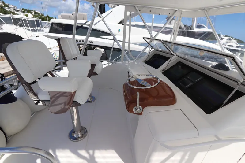 Slide: The Image of 2011 Viking 46 Convertible yacht helm with white seating and navigation controls. - 32