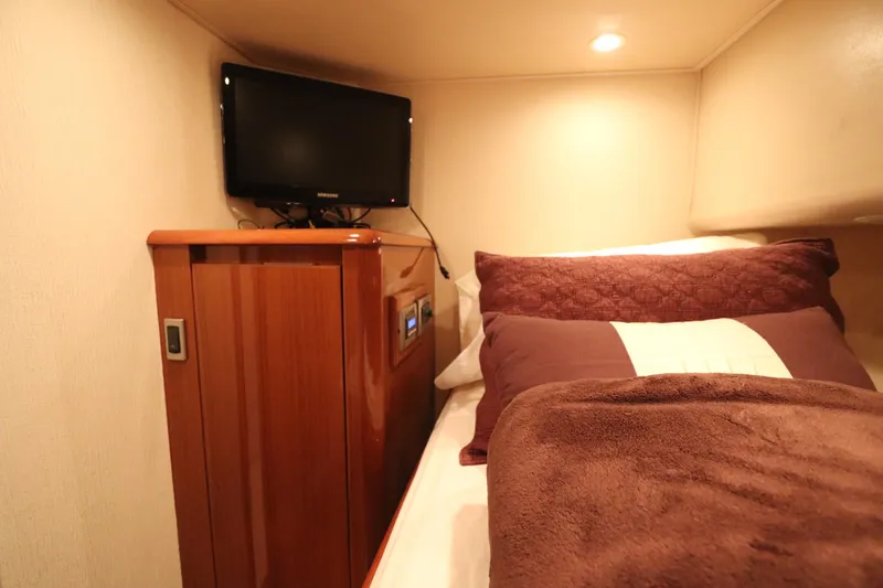 Slide: The Image of Cozy cabin interior of 2011 Viking 46 Convertible yacht with TV and plush bedding. - 9