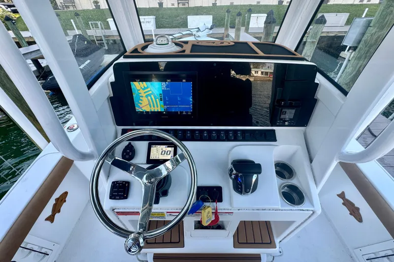 Slide: The Image of 2024 Sea Hunt BX 25 FS boat dashboard with steering wheel and navigation display. - 10