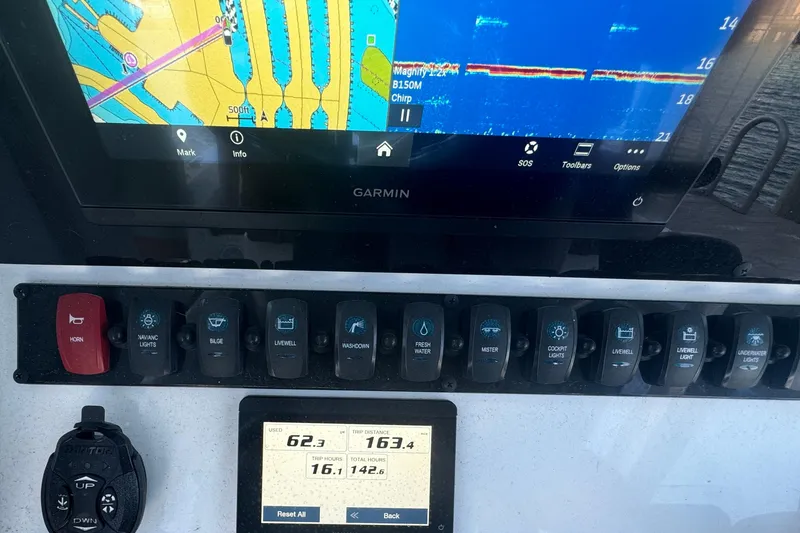Slide: The Image of 2024 Sea Hunt BX 25 FS dashboard with Garmin navigation and control switches. - 11