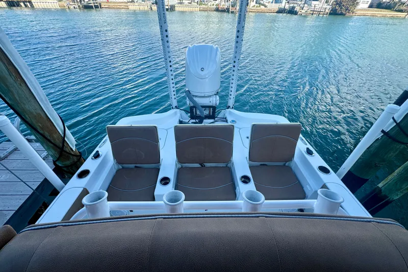 Slide: The Image of 2024 Sea Hunt BX 25 FS boat with seating and motor, docked on calm water. - 12