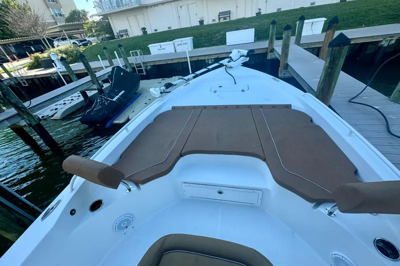 Slide: The Image of 2024 Sea Hunt BX 25 FS boat docked, featuring spacious deck and seating. - 14