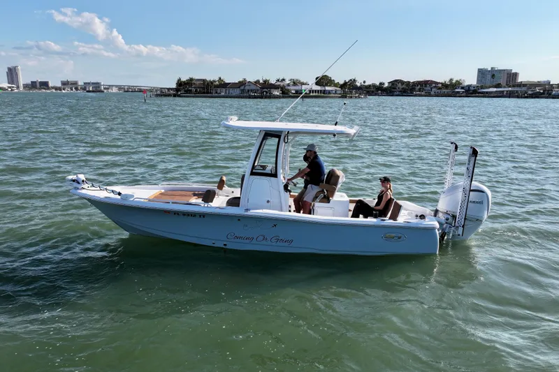 Slide: The Image of 2024 Sea Hunt BX 25 FS boat cruising on calm waters under a clear sky. - 19