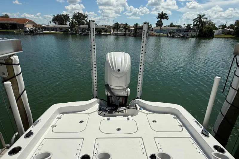Slide: The Image of 2024 Sea Hunt BX 25 FS boat docked on a serene waterfront with clear skies. - 4