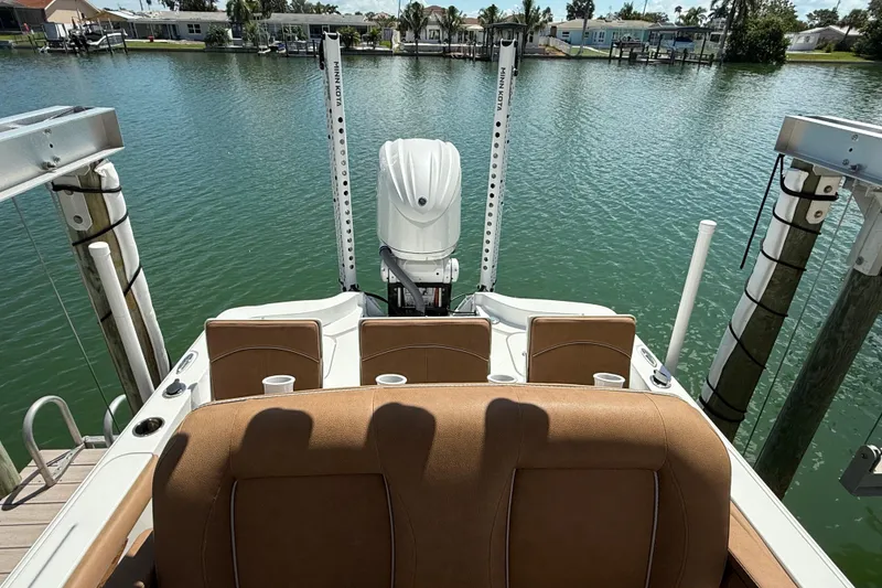 Slide: The Image of 2024 Sea Hunt BX 25 FS boat docked on calm water, showcasing seating and motor. - 5