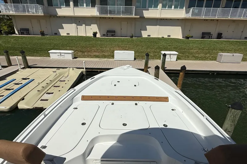 Slide: The Image of 2024 Sea Hunt BX 25 FS boat docked at a marina with waterfront view. - 6