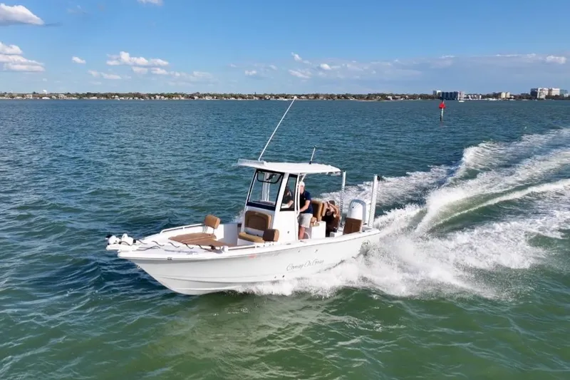Slide: The Image of 2024 Sea Hunt BX 25 FS boat cruising on open water under a clear blue sky. - 8
