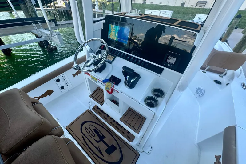 Slide: The Image of 2024 Sea Hunt BX 25 FS boat cockpit with steering wheel and navigation display. - 9