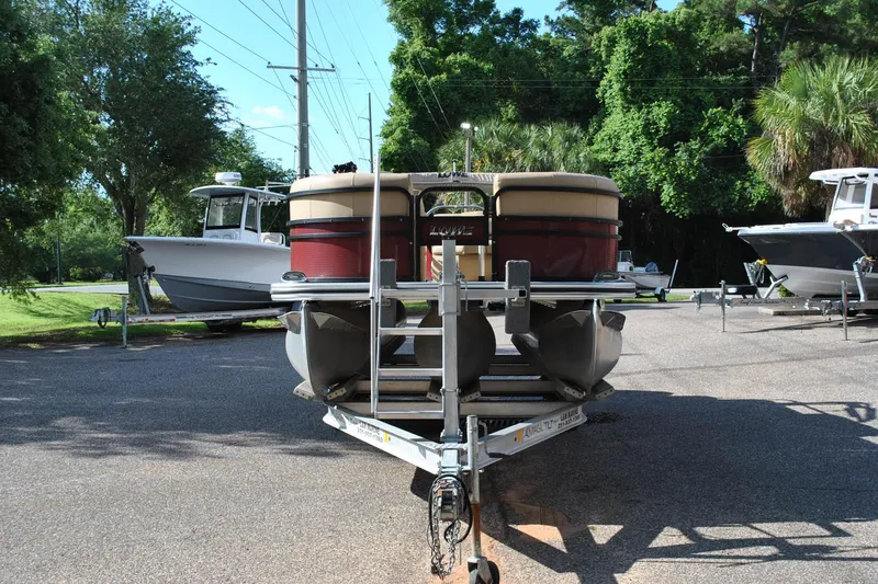 Slide: The Image of 2019 Lowe SF 232 Sport Fish pontoon boat on trailer, parked outdoors. - 2