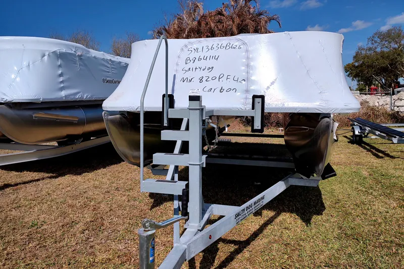 Slide: The Image of 2026 Sylvan MIRAGE 820 PARTY FISH 4.0 boat wrapped on trailer, grassy area. - 27