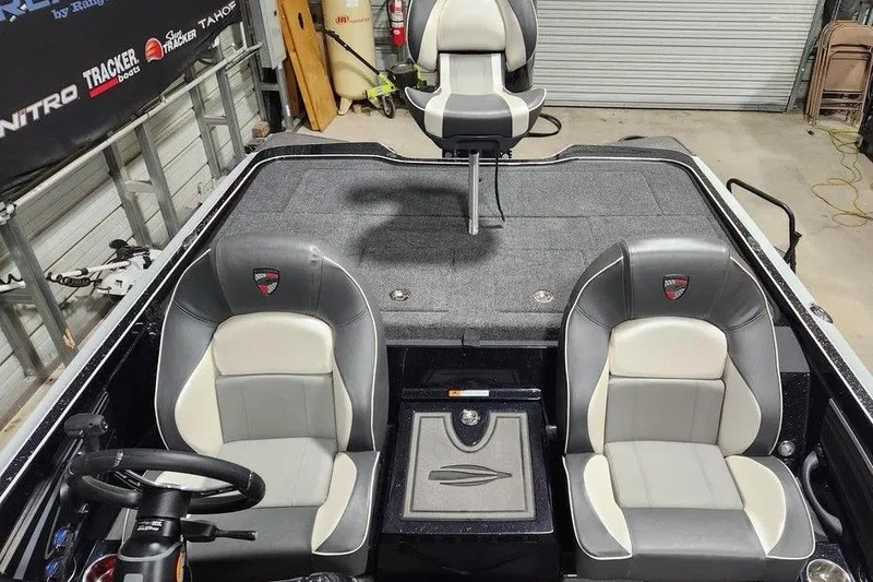 Slide: The Image of 2026 Triton 21XP Patriot boat interior with gray and white seating, steering wheel, and storage compartment. - 11