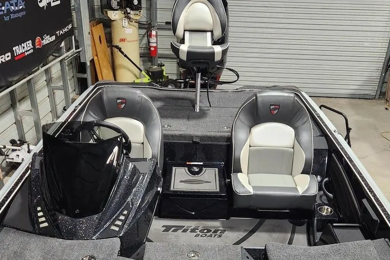 Slide: The Image of 2026 Triton 21XP Patriot boat interior with sleek seating and modern design in a garage setting. - 13