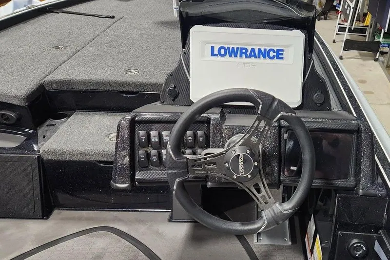 Slide: The Image of 2026 Triton 21XP Patriot boat dashboard with Lowrance HDS display and steering wheel. - 5
