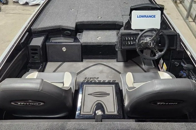 Slide: The Image of 2026 Triton 21XP Patriot boat interior with steering wheel and Lowrance display. - 7