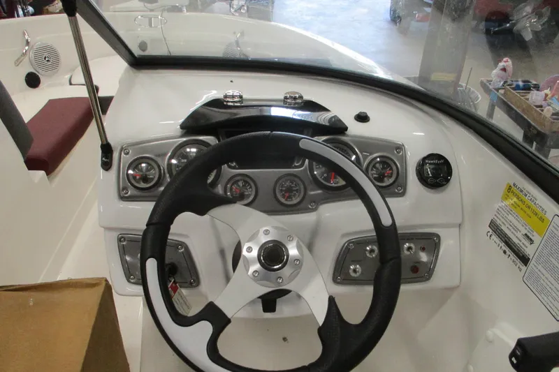 Slide: The Image of 2024 Tahoe 200 S boat dashboard with steering wheel and instrument panel. - 12