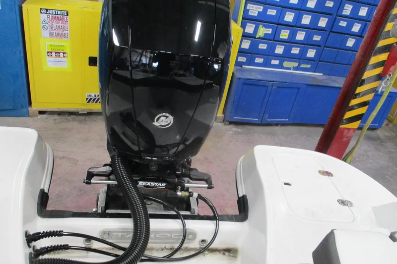 Slide: The Image of 2024 Tahoe 200 S boat engine in a workshop with safety cabinets and storage. - 19