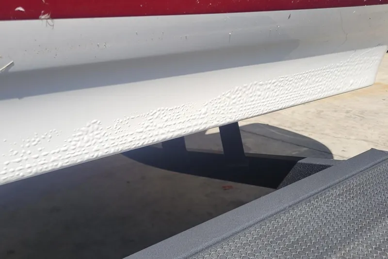 Slide: The Image of 2024 Tahoe 200 S boat hull with visible paint blistering and texture. - 20